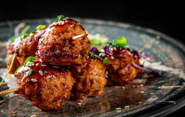 deep fried meatballs in plate on black wooden table background