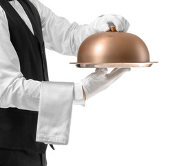 Handsome male waiter with tray and cloche on white background