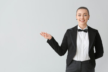 Beautiful female waiter on grey background