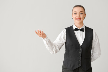 Beautiful female waiter on grey background