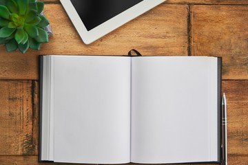 Blank open notebook with tablet wooden table, desktop. Top view image.