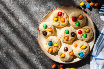 Homemade cookies with colorful candies. Grey background.