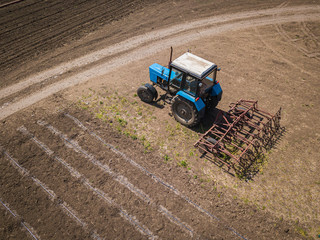 Tractor parked near the field. Aerial drone photo.