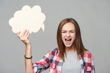 Angry screaming teen girl holding thinking bubble