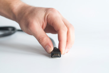 HDMI cable. USB plug. In hand on a white background