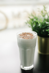 milkshake with chocolate chips on a background of black table and greenery