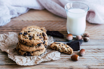 Biscuits cookies aux pépites de chocolat et noisettes avec un verre de lait