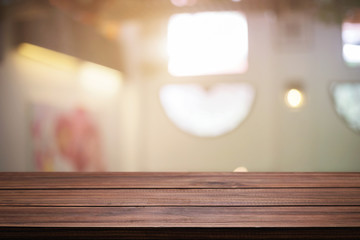 Obraz premium Empty wooden desk space and blurry background of restaurant vintage tone for product display montage.