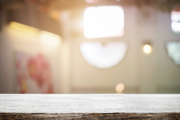 Empty wooden desk space and blurry background of restaurant vintage tone for product display montage.