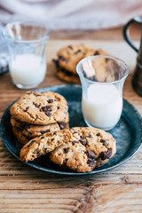 Biscuits aux pépites de chocolat brun et aux noisettes avec un verre de lait frais