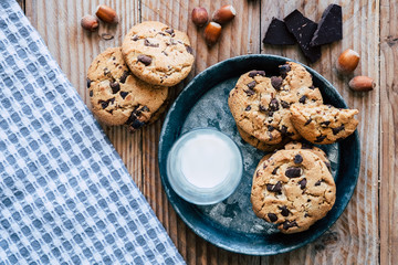 Biscuits aux pépites de chocolat brun et aux noisettes avec un verre de lait frais