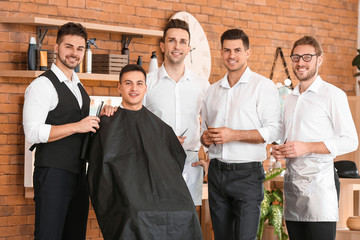 Professional hairdresser teaching young men in salon