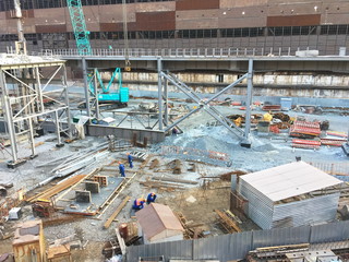 Large construction site with a lot of construction equipment, cranes, workers and building materials