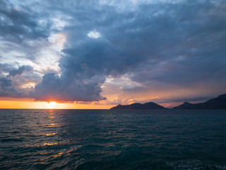 Epic sunset (dawn) on the sea. Waves are breaking on stones.