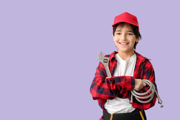 Portrait of little plumber on color background