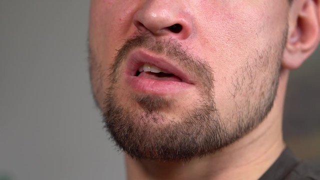 A man talks to the camera - closeup on his mouth