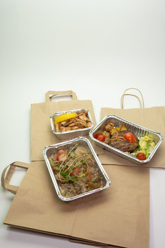 Delivery of delicious healthy food in foil boxes. Concept of food delivery in quarantine, self-isolation.