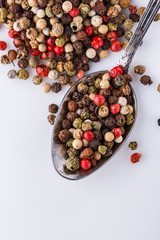 mix of peppercorns on white acrylic background