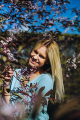 Fototapeta premium Beautiful spring girl in blooming tree