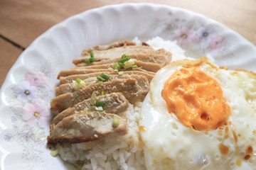 Fried egg with grilled beef and rice on a plate