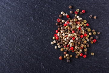 mix of peppercorns on a dark stone background
