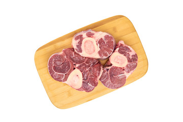 Three slices of fresh shank steak lie on the cutting board on a white background. Fresh Osso Bucco steaks. The view from the top.