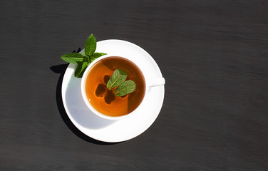 Alternative mint tea in white cup on gray background