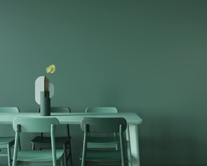 Dining room in monochrome green with a large table, chairs and a vase.