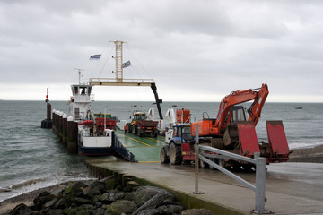 Returning home after a working day. Transportation of heavy equipment through Carlingford Bay.Ireland.