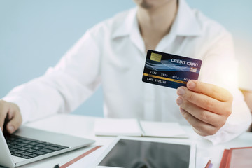 businessman in white shirt entering security code with digital laptop computer and paying with mock up credit card on desk at home, shopping, payment online, electronic pay, digital technology concept