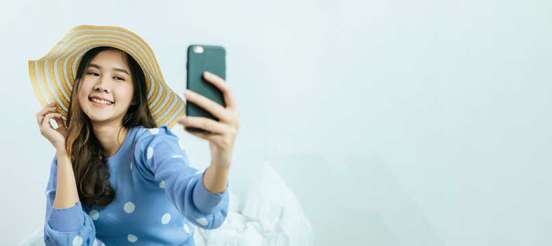 wide banner with copy space. happy pretty woman taking selfie with fashion hat and video call on mobile phone at home, summer holiday vacation, internet technology, social network, quarantine concept
