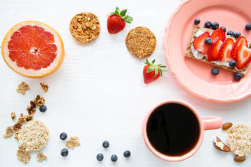 A cup of black coffee and tasty fruit sandwich on white table.
