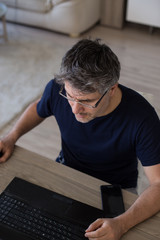 Obraz premium Middle age man working from home using his laptop