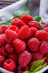 juicy fresh natural raspberries on a dark wooden rustic background
