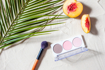 Vacation. A sculpting palette and brush lie on the beach sand, surrounded by vibrant fruits,...