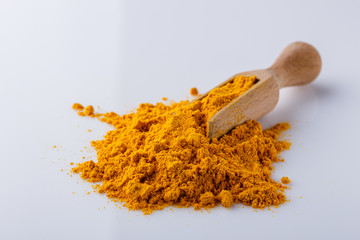 natural turmeric powder on white acrylic background