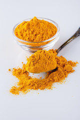 natural turmeric powder on white acrylic background