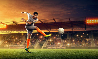 Soccer player in action. Kicking the ball. Sports stadium with crowded tribunes and fans cheering
