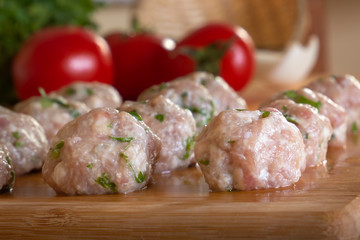 Raw homemade meatballs with minced meat with herbs. Close-up
