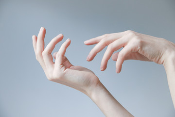 Tender female hands on a pale blue background.