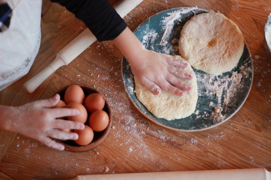 woman cooks Georgian cheese-pie (khachapuri)