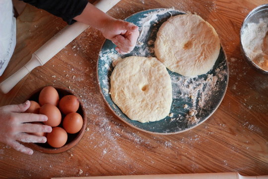 woman cooks Georgian cheese-pie (khachapuri)