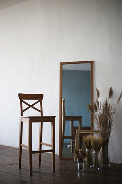 composition: a chair, a mirror, dried flowers