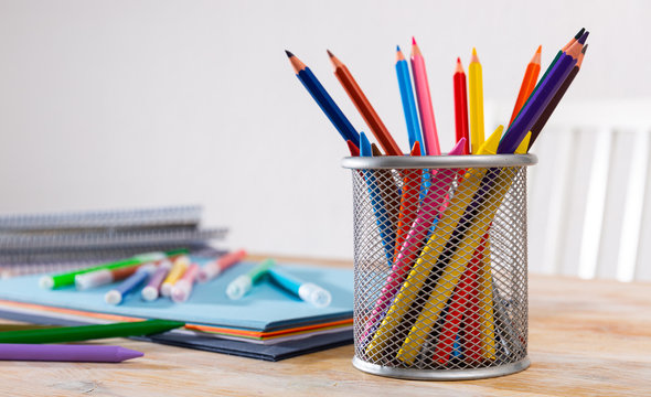 Pencils, papers and workbooks on desk