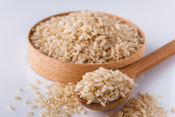raw brown rice on white acrylic background