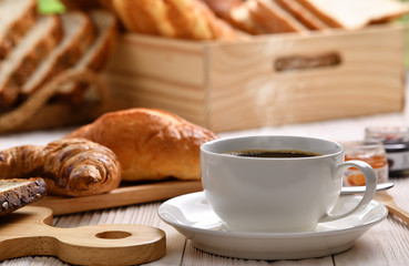  Coffee cup with smoke with breads or bun, croissant and bakery on white wooden table