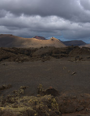 Mondlandschaft auf  der Vulkan-Insel Lanzarote, Canaren mit düster bewölktem Himmel und einzelnen Sonnenstrahlen, Schrofen Felsen © Basaltblick