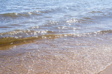 Golden sandy seashore with transparent wave