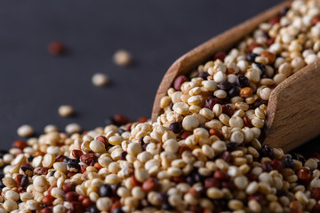 mix of quinoa grains on a dark stone background