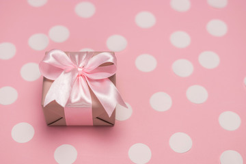 Gift box with pink ribbon bow on pastel pink background with white confetti. Banner for Womens day, Birthday or Mothers Day. Best gift for women concept. Close up free space.  